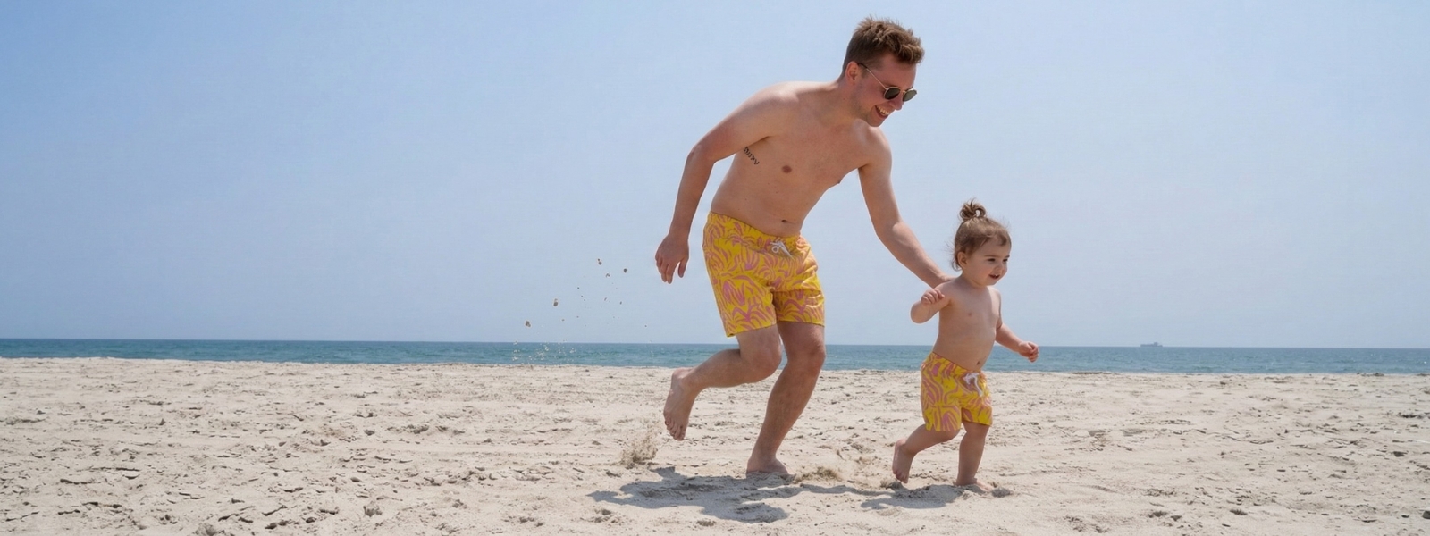 dad and son wearing matching swimtrunks at the bach
